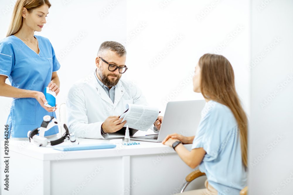 Young patient at an appointment with otolaryngologists, sitting during the consultation in the bright ENT office interior Young patient at an appointment with otolaryngologists, sitting during the consultation in the bright ENT office interior