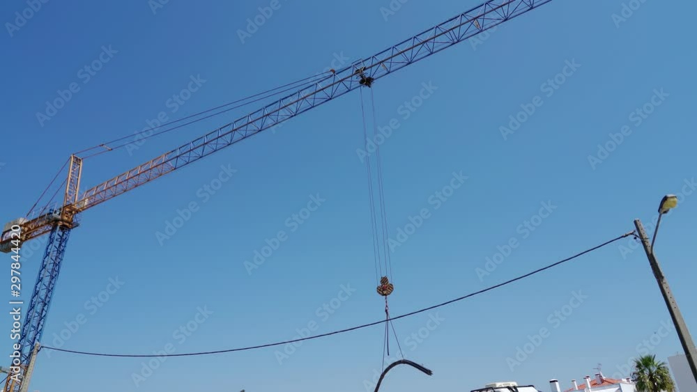 A crane on a construction site carries material. In Portugal. A crane on a construction site carries material. In Portugal.