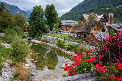 Beautiful wooden huts by the mountain river in Stara Fuzina village in Triglav National Park, Slovenia photo