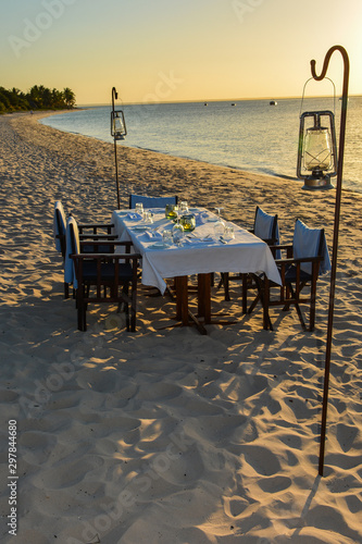 table and chairs set for sunset dinner on the beach on Benguerra Island
