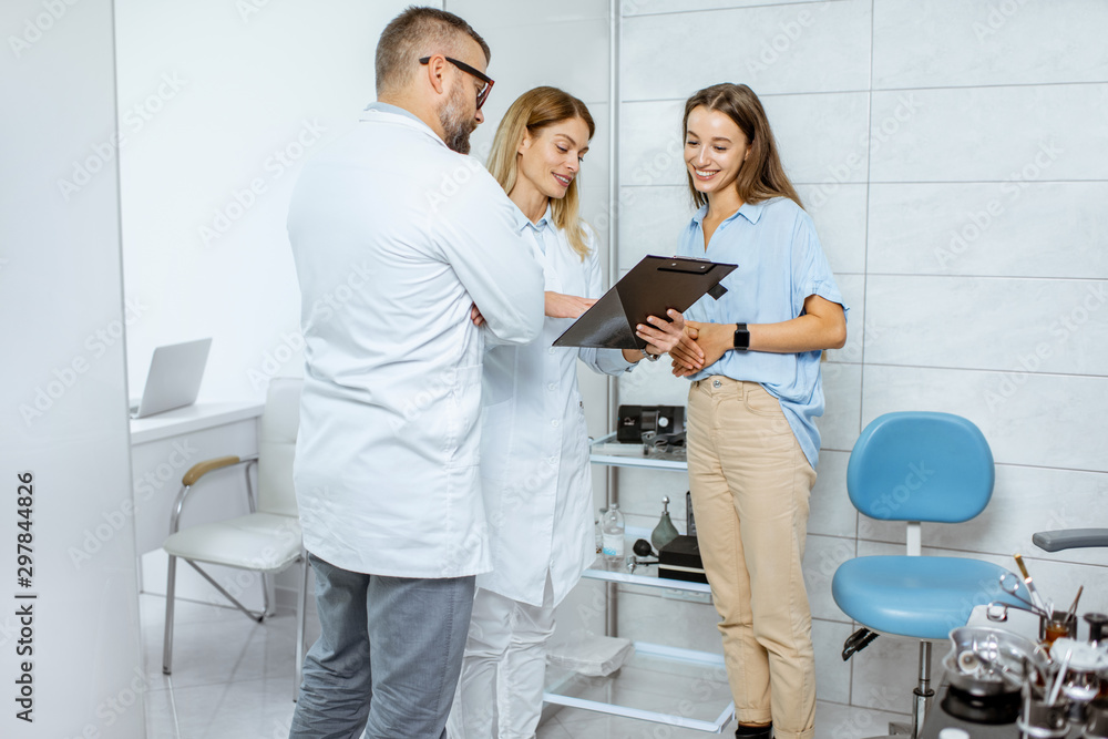 Young patient with two doctors during a medical consultation standing together at the ENT office Young patient with two doctors during a medical consultation standing together at the ENT office