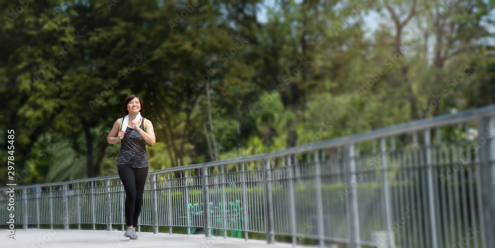 Portrait of an Asian woman wearing sport clothes, jogging and workout in the park in the morning. With good weather Exercise every day will make the body healthy and not sick. Concept Health insurance