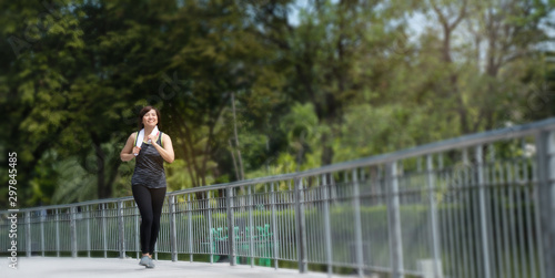 Bild auf Leinwand Portrait of an Asian woman wearing sport clothes, jogging and workout in the park in the morning