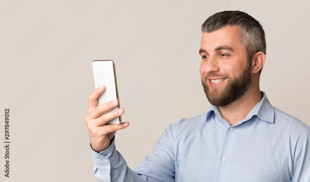 Cheerful man using facial recognition on modern smartphone Cheerful man using facial recognition on modern smartphone