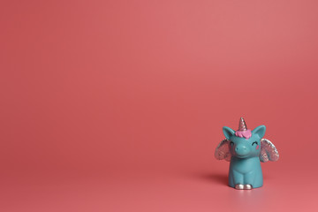 A blue unicorn with  silver wings  and pink hair on a pink background. A magical children 's toy isolated. Banner, postcard, copy space.