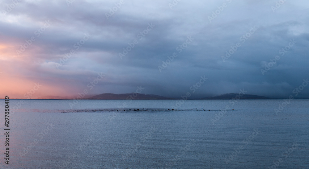 Galway Bay, Ireland at dawn with view across to the Burren. Taken from Salthill beach in the early morning at sunrise