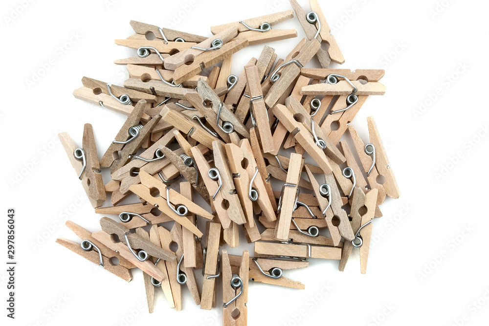 Many wooden clothespins in a pile isolated on white background