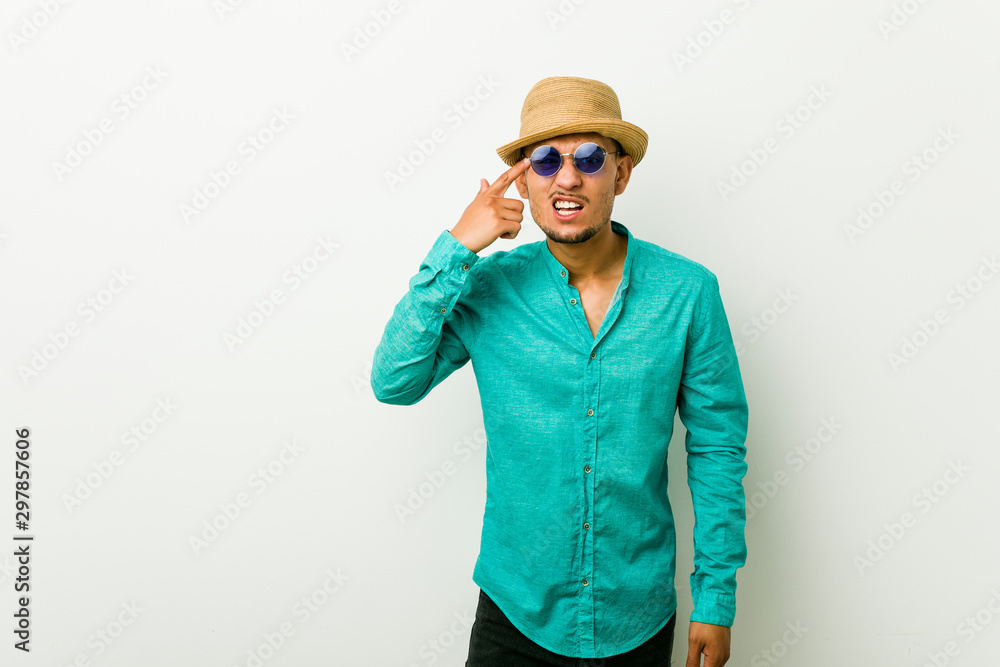 Young hispanic man wearing a summer clothes showing a disappointment gesture with forefinger.