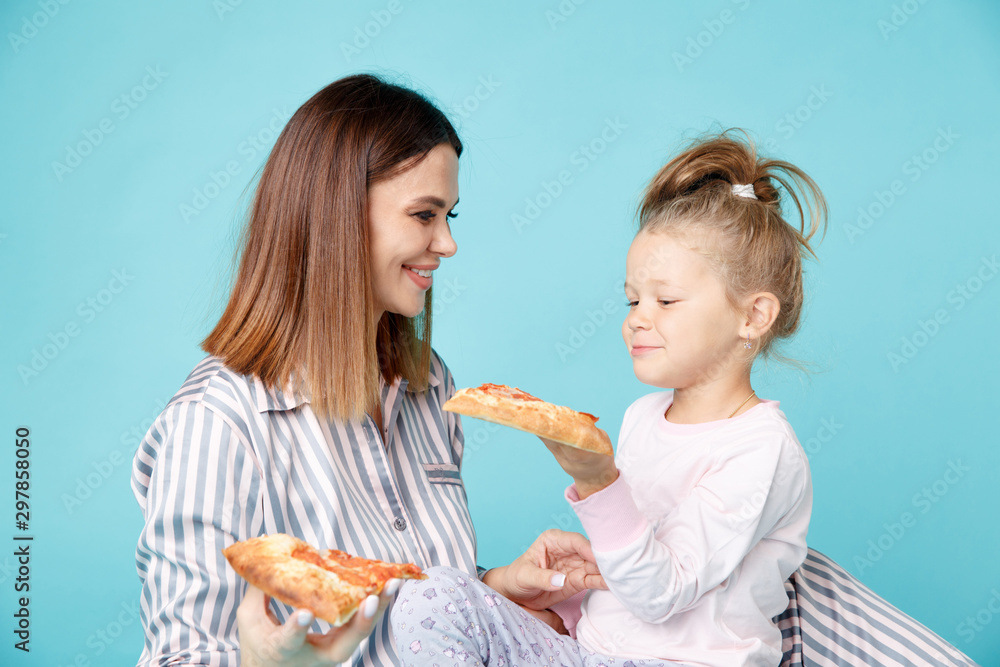 Mom and kid eating pizza together in the morning