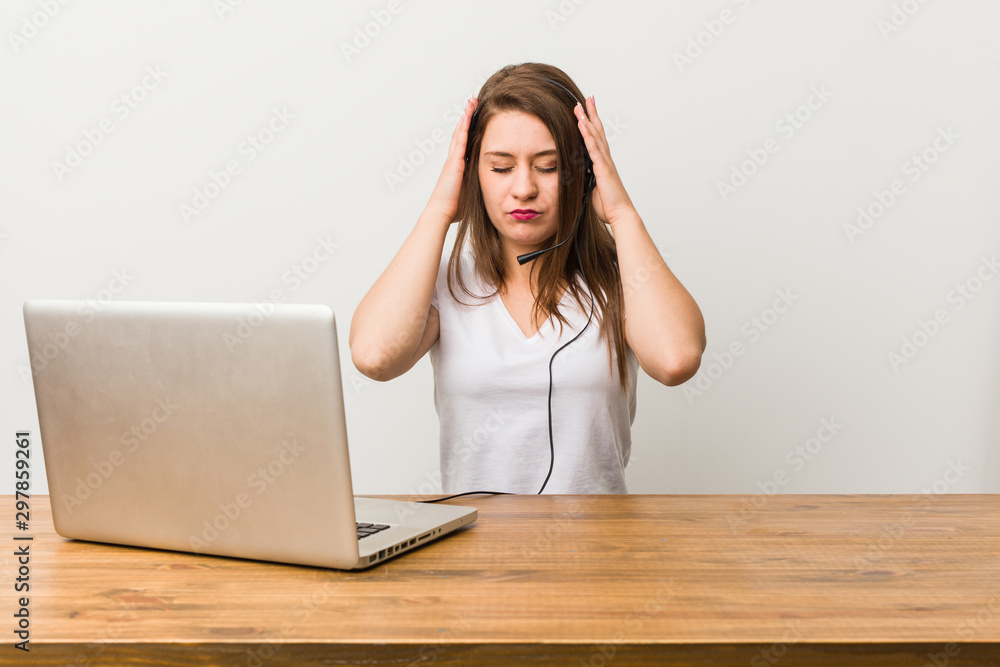 Young telemarketer woman touching temples and having headache.