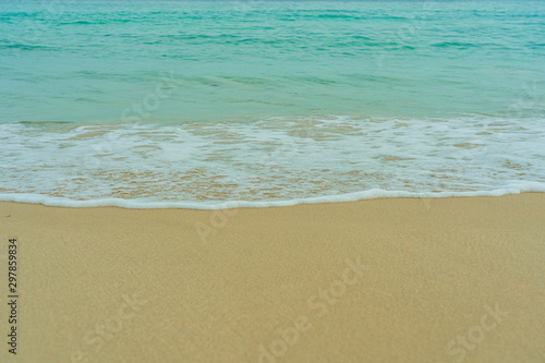 The waves of the turquoise sea swept into the sand beach. © Photon