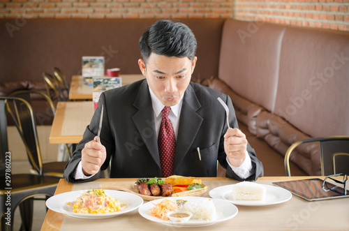 business man happy eating foods in  restaurant