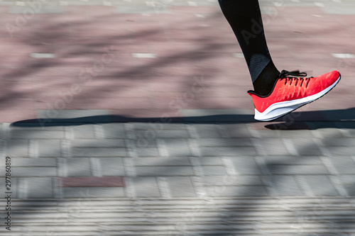 Running leg on sunny pavement.