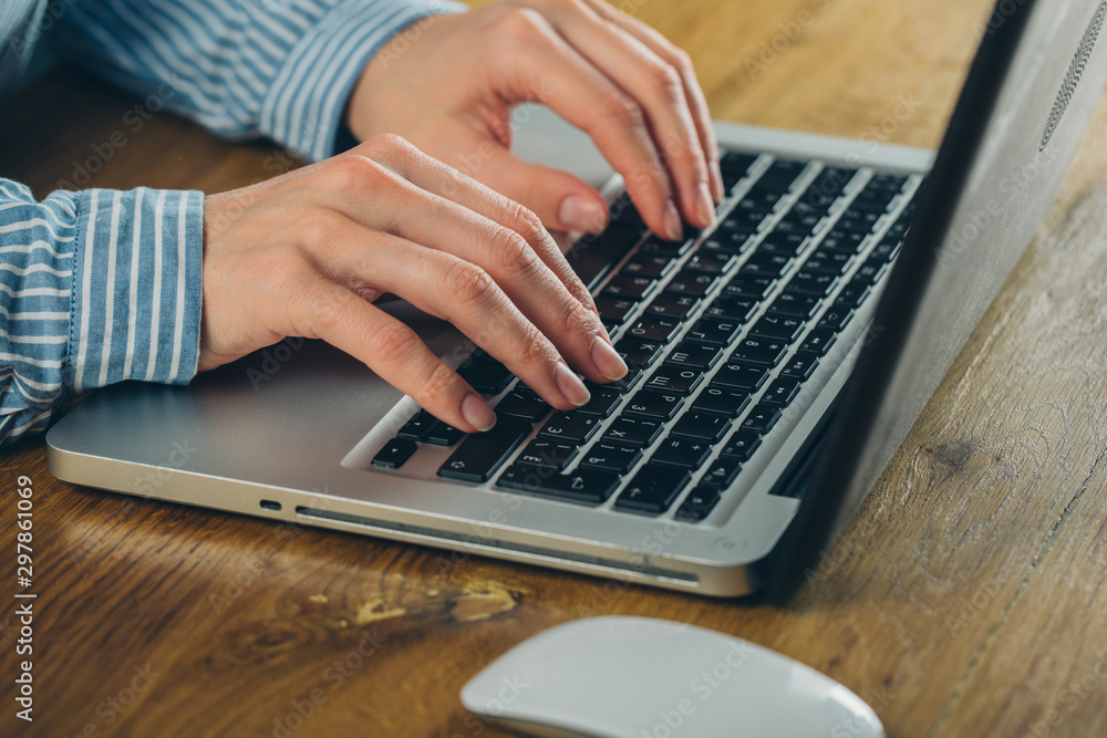 Woman working at home office hand on keyboard close up