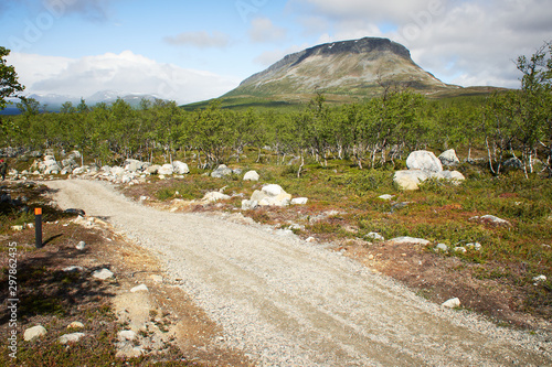 Idyllic countryside road and mountain view at the Saanatunturi fell in Kilpisjarvi, Finnish Lapland, Finland. photo
