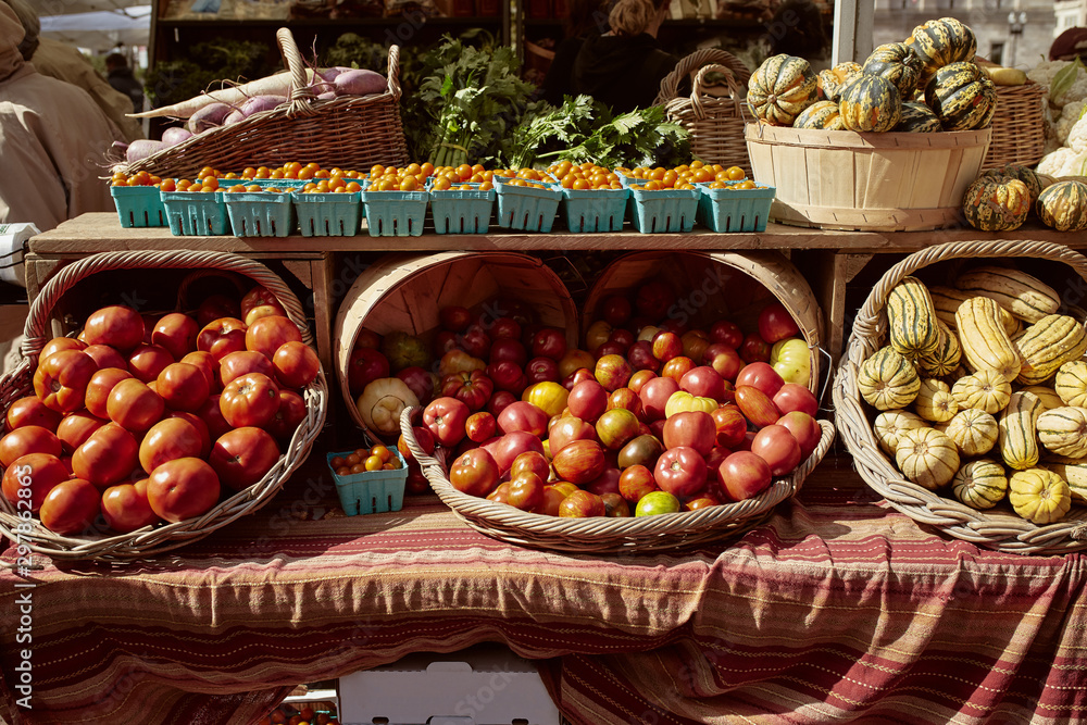 Rustic baskets filled with heirloom tomatoes and winter squash for sale at a farmers market in Copley Square.  Cucurbita maxima & Lycopersicon esculentum