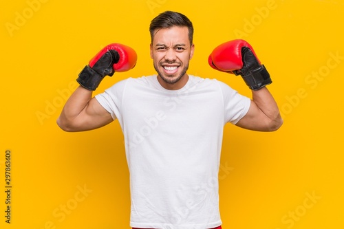 Young south-asian boxer man wearing red gloves.