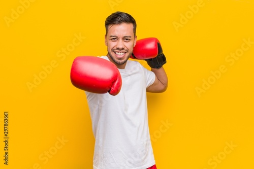 Young south-asian boxer man wearing red gloves. © Asier