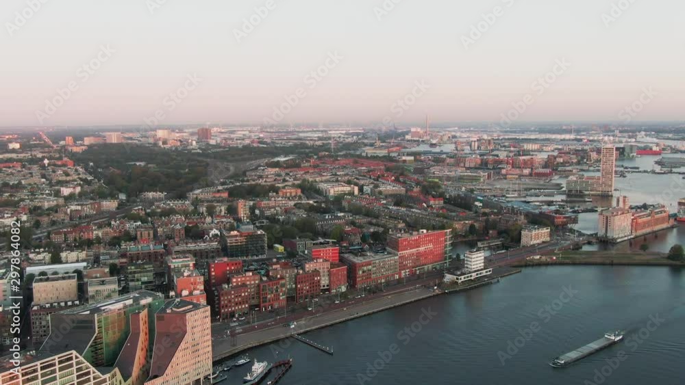 Aerial Drone Shot of the Westdock Canal of Amsterdam, Netherlands on a beautiful sunrise morning with modern architecture Aerial Drone Shot of the Westdock Canal of Amsterdam, Netherlands on a beautiful sunrise morning with modern architecture
