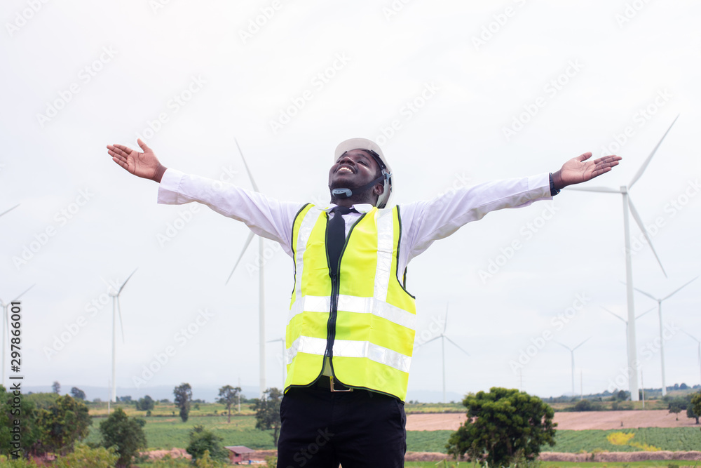 Freedom african engineer man standing with wind turbine Freedom african engineer man standing with wind turbine