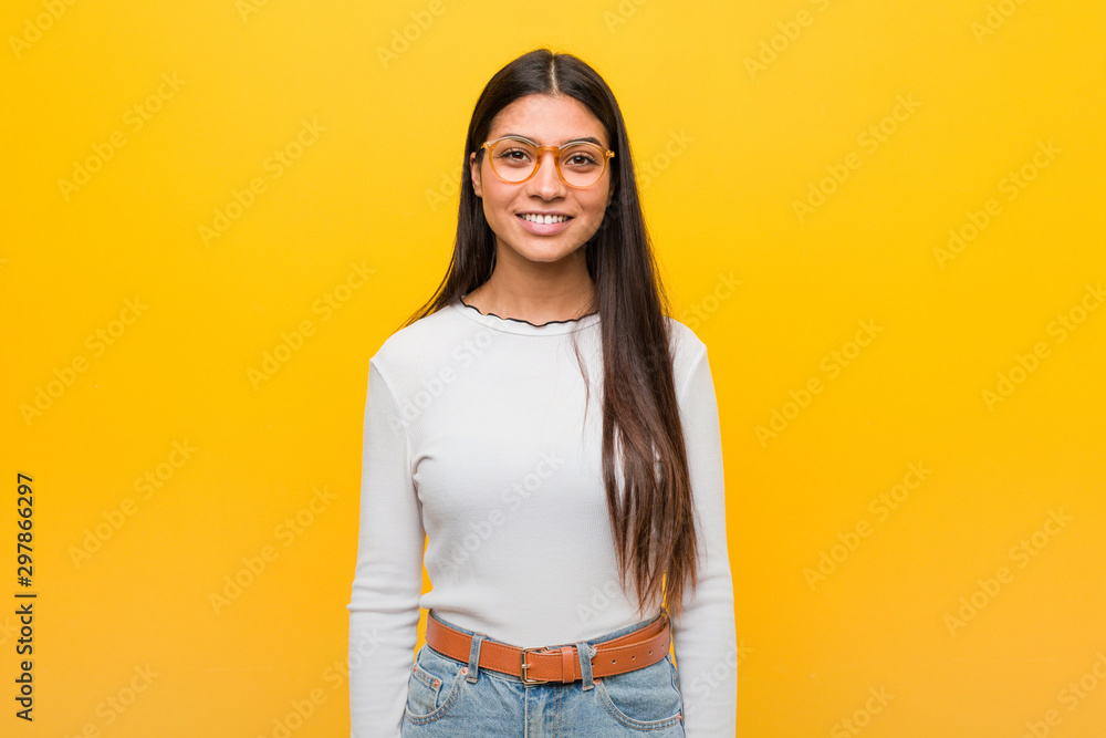 Young pretty arab woman against a yellow background happy, smiling and cheerful. Young pretty arab woman against a yellow background happy, smiling and cheerful.