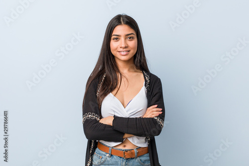 Young natural and pretty arab woman who feels confident, crossing arms with determination. photo