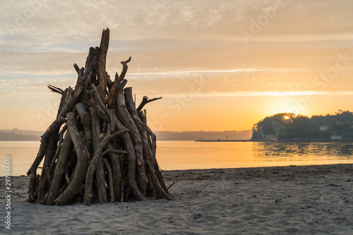 A big bonfire in the beach at sunset with yellow colors