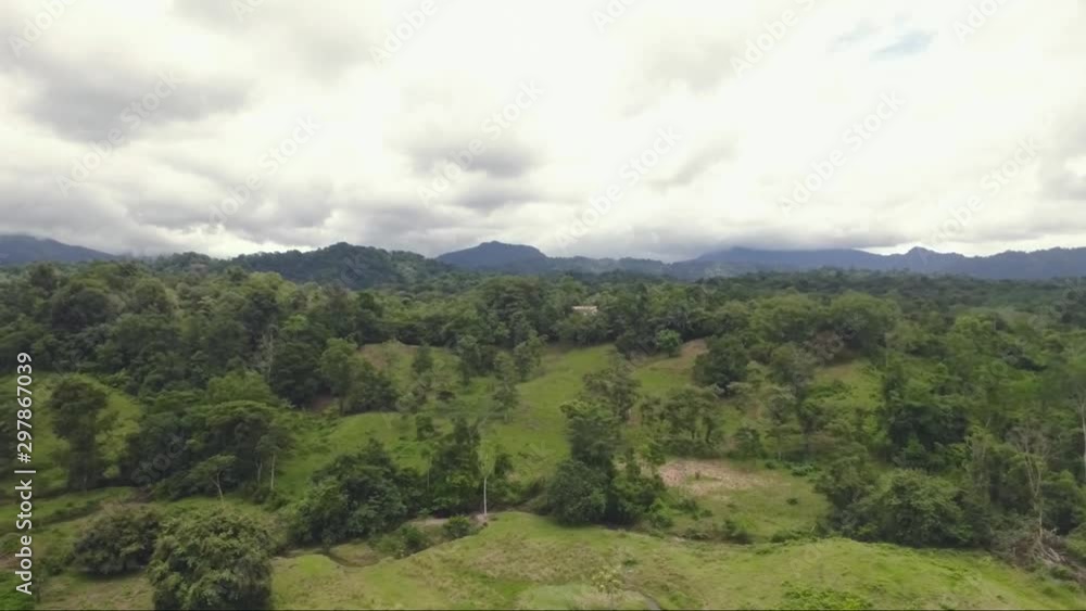Costa Rican Rocky road with large old trees, lots of green, and a beautiful valley leading to the base of the San Isidro mountains in Costa Rica. Located in Costa Rica pueblo called naranjito. Costa Rican Rocky road with large old trees, lots of green, and a beautiful valley leading to the base of the San Isidro mountains in Costa Rica. Located in Costa Rica pueblo called naranjito.
