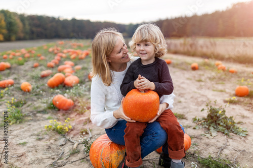 Mother and son in pumpkin patch field