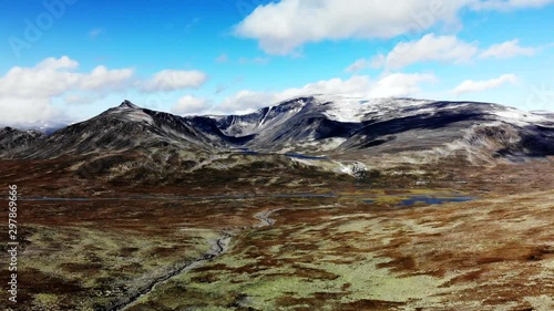 Aerial: wide shot of the vast Norwegian landscape in front of the Glittertind mountain range. photo