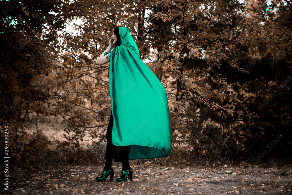 Woman in gothic style wear green carnival cloak, concept of simple Halloween ideas Woman in gothic style wear green carnival cloak, concept of simple Halloween ideas