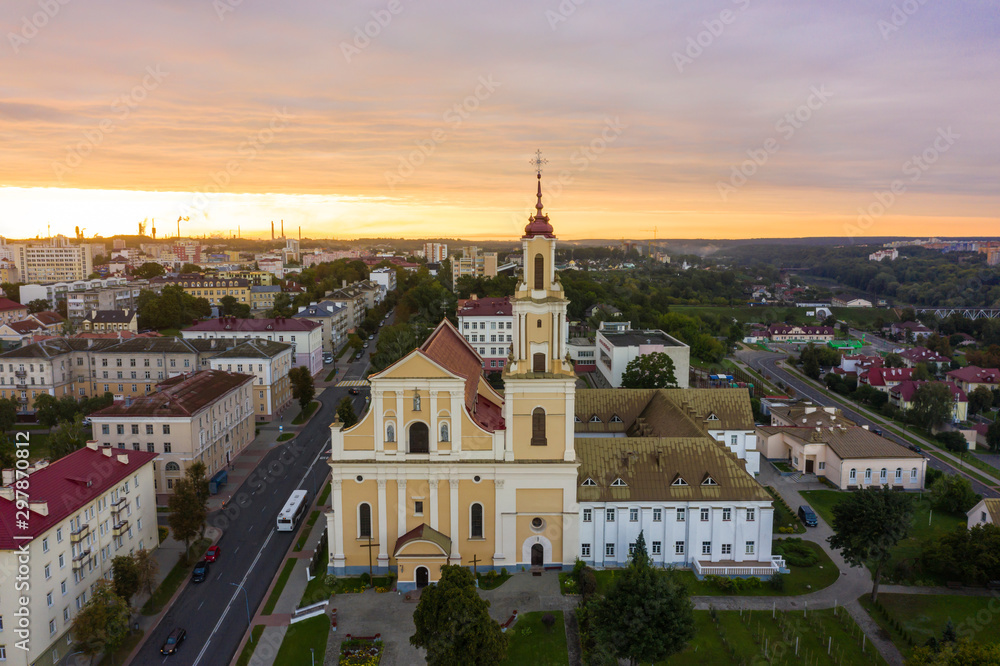 Holy Cross Church And Traffic In Mostowaja And Kirova Streets At Evening in the morning light. Grodno city in Belarus. Aerial view from a drone