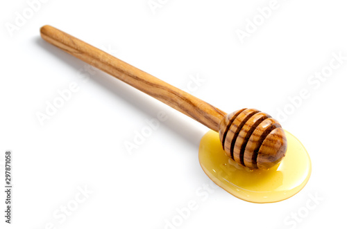 Spoon with honey. Honey flows from a spoon to a table. White isolated background.