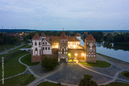 Mir Castle and its reflection in the lake in summer. Twilight and late evening. Aerial view from a drone