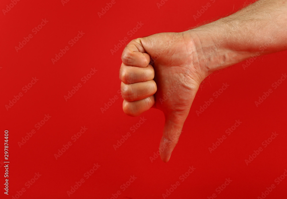 Man hand with dislike gesture over red Man hand with dislike gesture over red