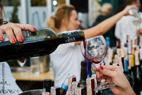 Female hand pours wine into a glass photo