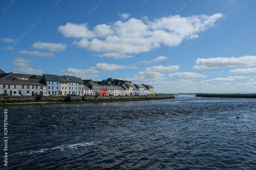 Famous view of the brightly painted houses of Galway city and the River Corrib rushing past on a sunny summer day Famous view of the brightly painted houses of Galway city and the River Corrib rushing past on a sunny summer day