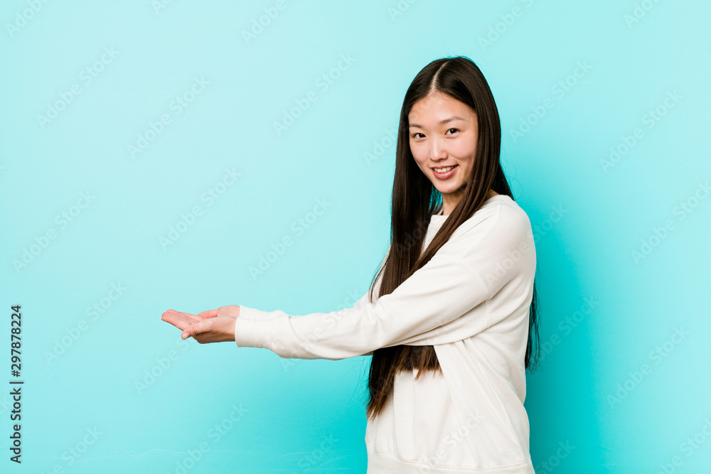 Young pretty chinese woman holding a copy space on a palm. Young pretty chinese woman holding a copy space on a palm.
