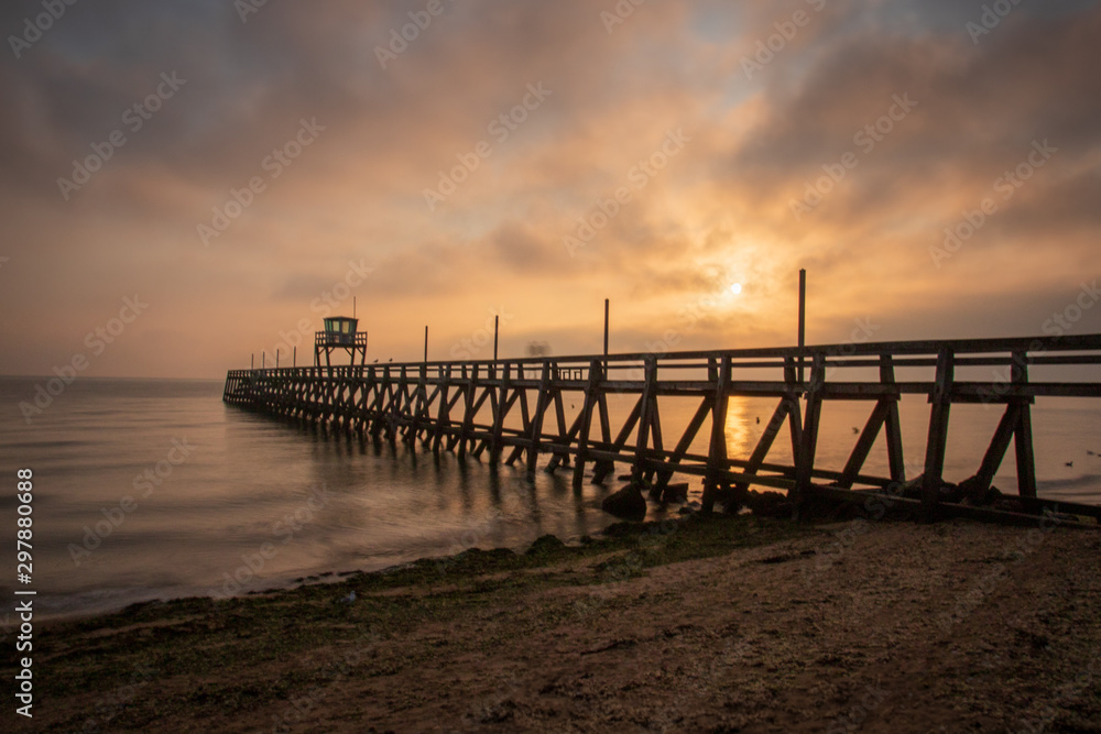 Obraz premium Lever de soleil sur le ponton de luc sur mer en septembre