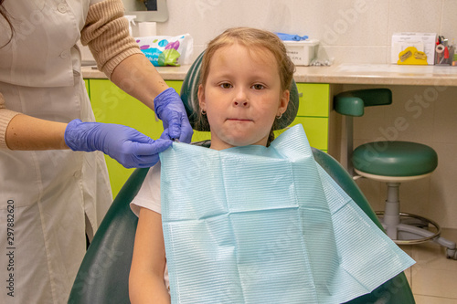Little Caucasian girl treats teeth at the dentist
