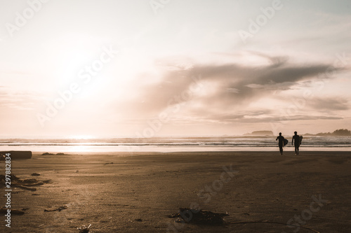 silhouette of surfers on beach at sunset