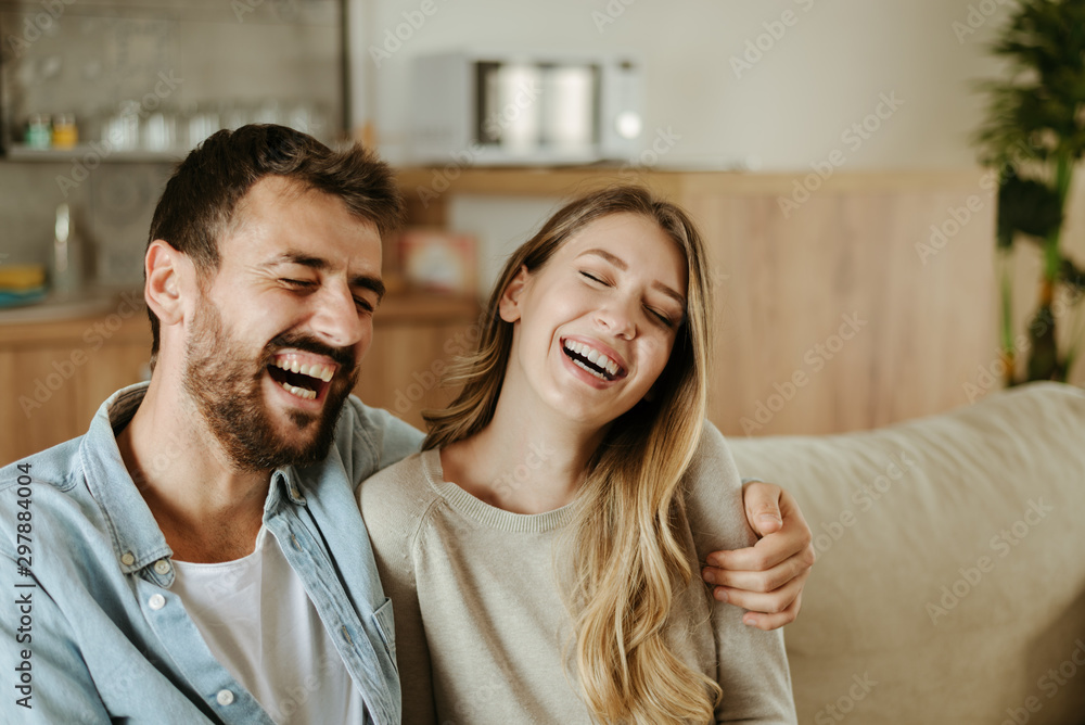 Happy young couple laughing while talking about something Happy young couple laughing while talking about something