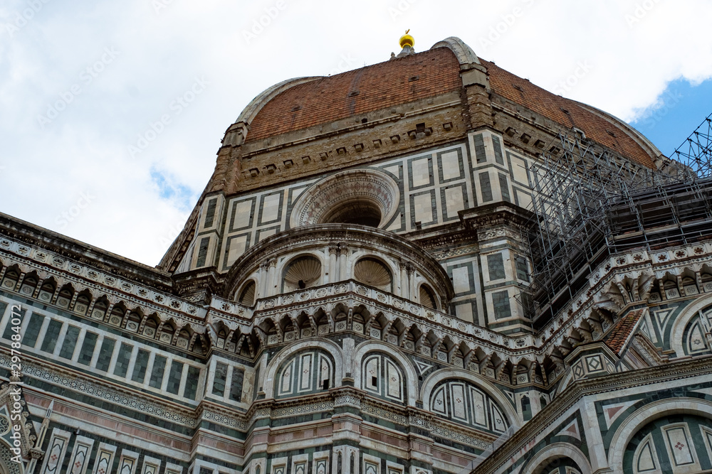 Florence's Santa Maria del Fiore Dome seen from the side with clouds.