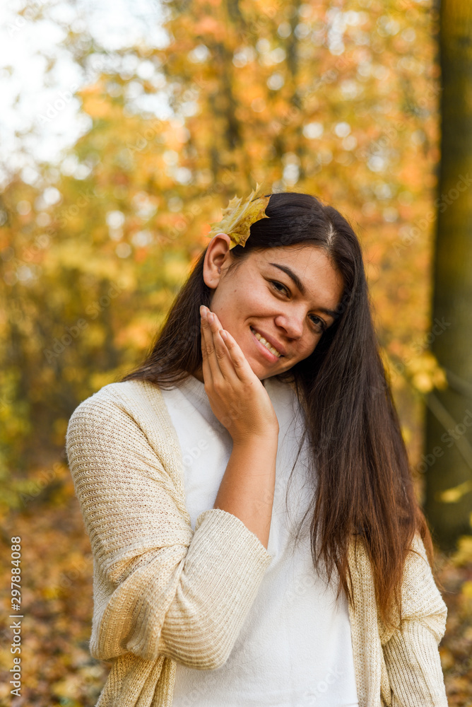 Beautiful brunette in white sweater strolls in the autumn park Beautiful brunette in white sweater strolls in the autumn park