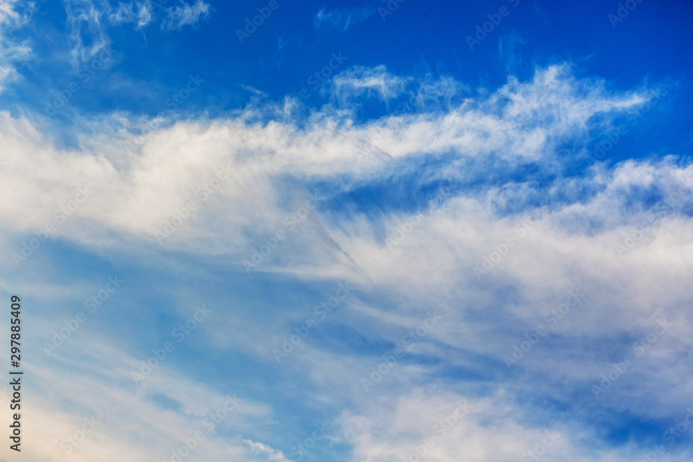 Blue sky with white clouds of different shapes_