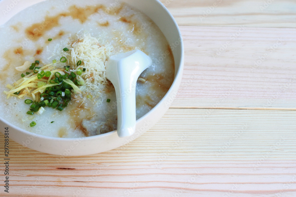 Congee, Rice porridge, Rice gruel, Rice soup, joke (China) on wooden table background, Top view, Selective and soft focus. Congee, Rice porridge, Rice gruel, Rice soup, joke (China) on wooden table background, Top view, Selective and soft focus.