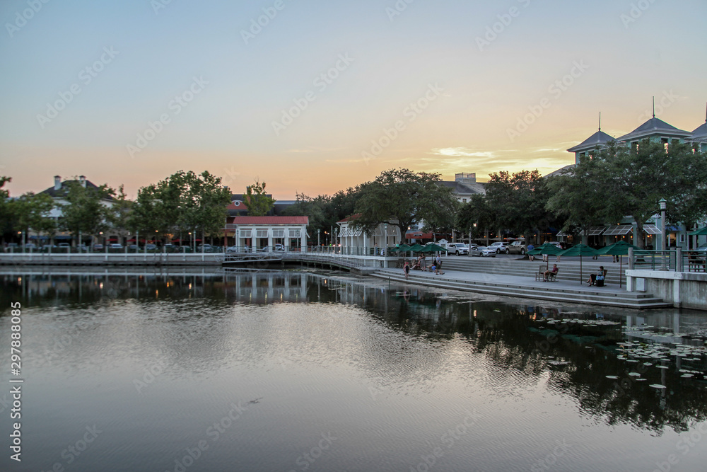 Fototapeta premium The magnificent sunset landscape at Celebration, Orlando, Florida, USA. A modern design leisure area in a wooded area, the water mirror on the lake reminiscent of nature.