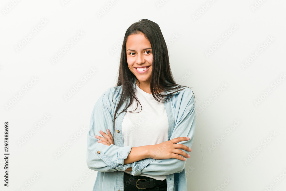 Young hispanic woman who feels confident, crossing arms with determination. Young hispanic woman who feels confident, crossing arms with determination.