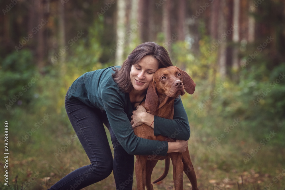 Φωτογραφία Happy young woman with a hungarian viszla in the autumn forest