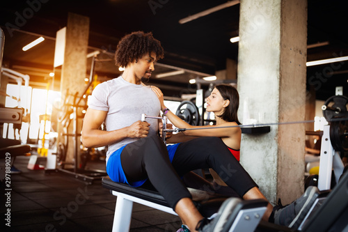 Fitness instructor exercising with client at the gym.